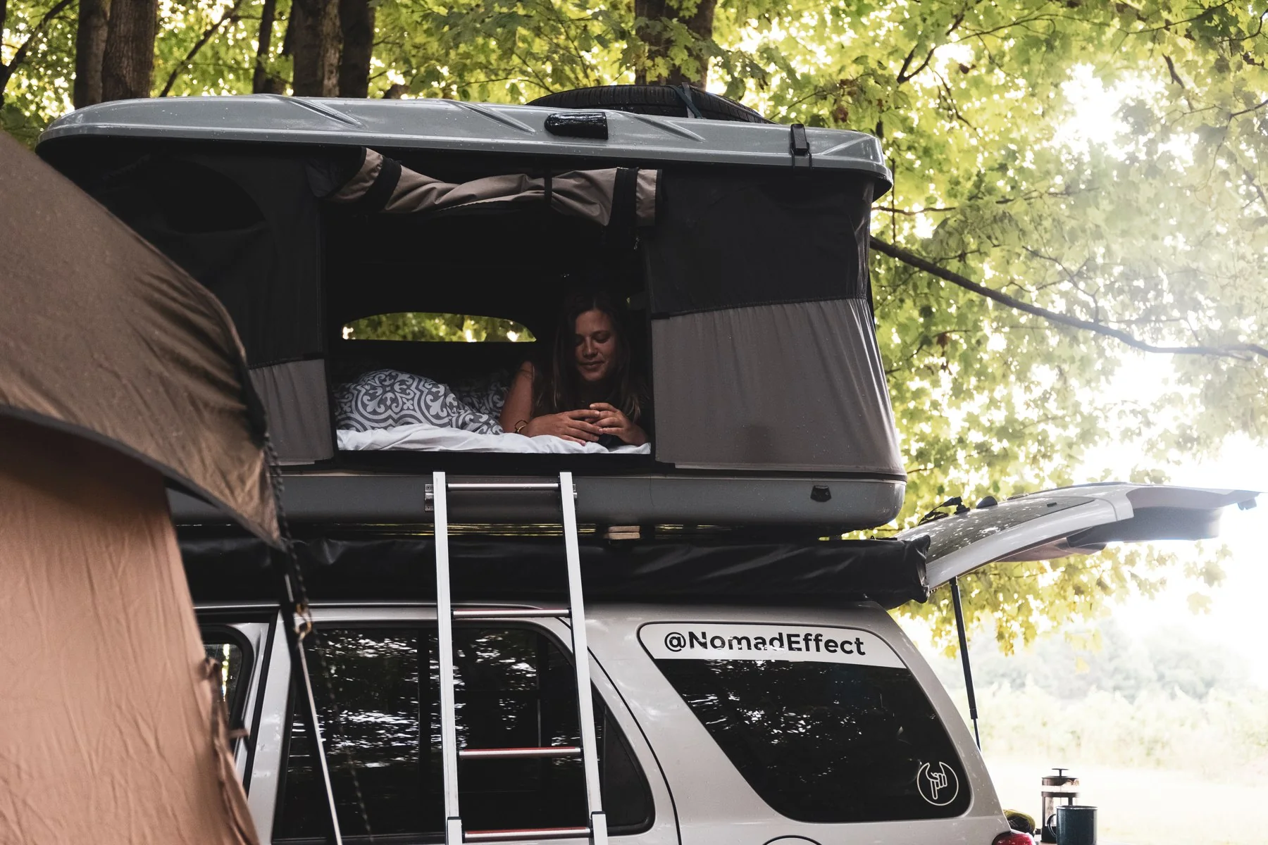Sofia in the rooftop tent on our Ford Escape at a Michigan campsite