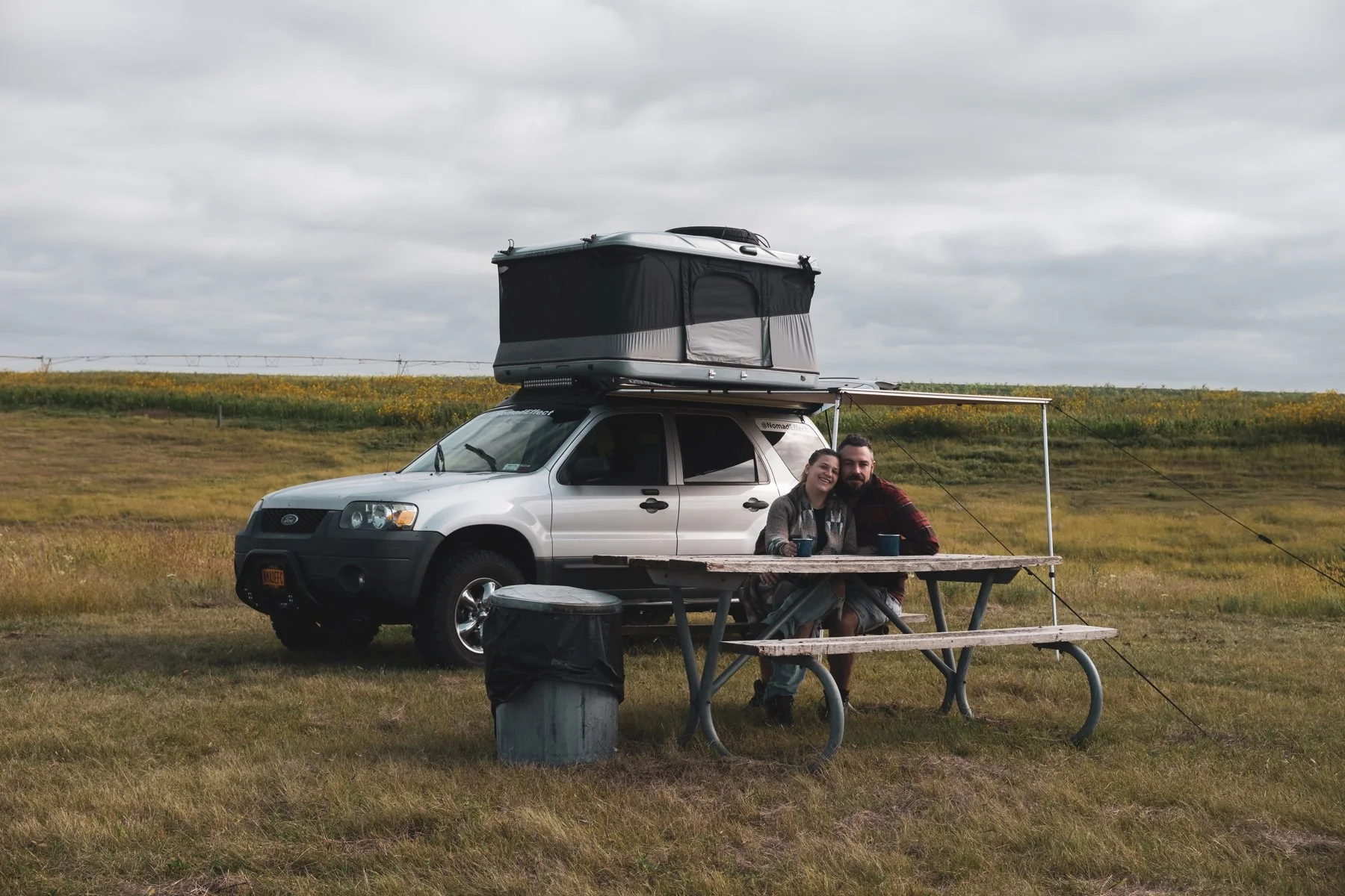 Sofia and Ben at a picnic table beside the Ford Escape in Nebraska