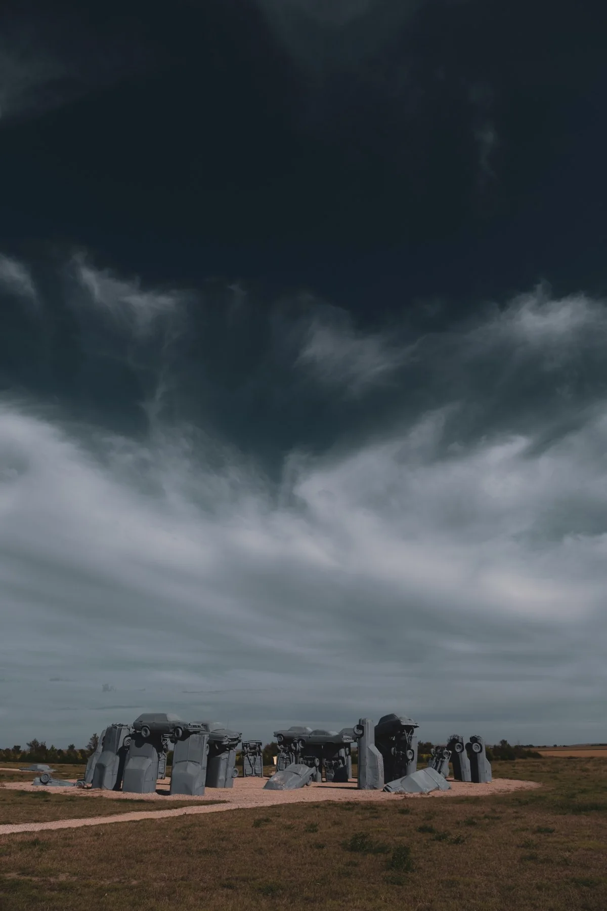 Stone sculptures beneath dark storm clouds in Nebraska