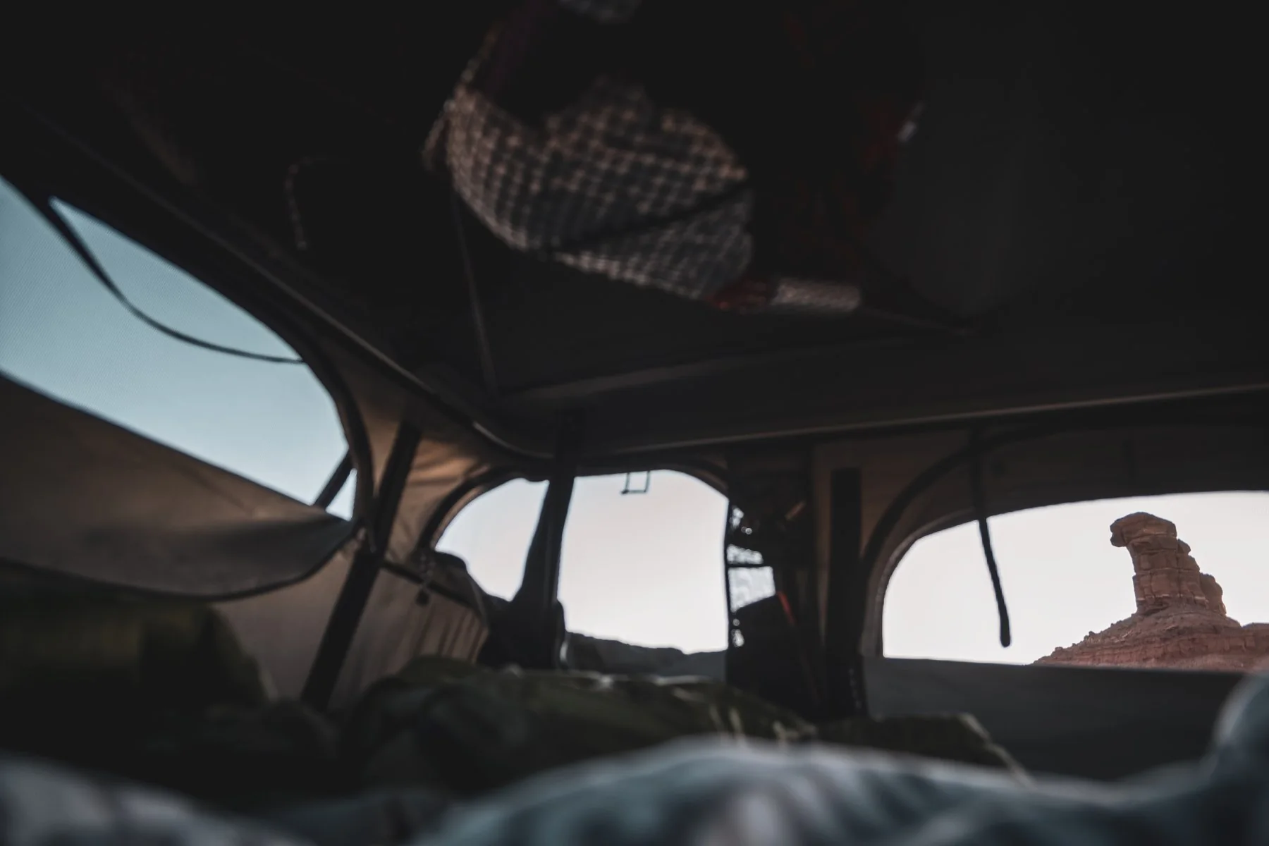 Looking out from the rooftop tent towards a desert rock formation