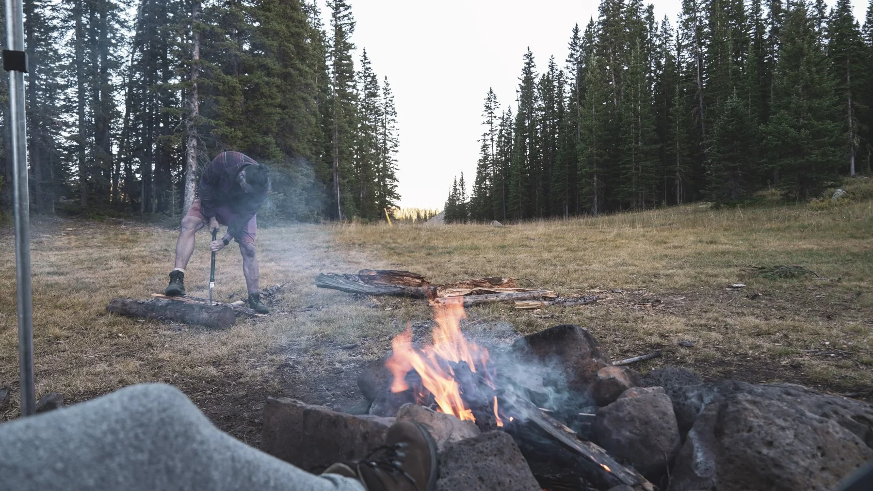 Relaxing beside a campfire in a forest clearing near Twin Lakes